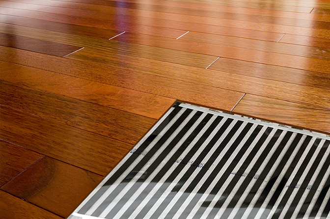 FilmHeat radiant floor heating element shown under hardwood